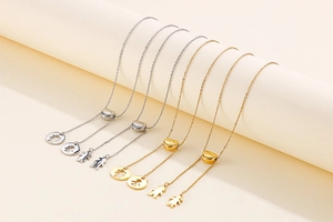 Vue détaillée de colliers cœur dorés et argentés avec pendentifs garçon et fille en studio