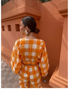 Detail of orange checkered crop top and pants with pleated texture and embroidery