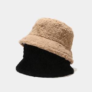 Detail of khaki and black fuzzy bucket hats showing soft faux fur plush texture