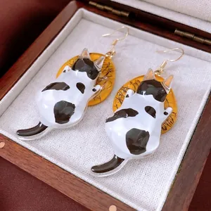 Handcrafted resin cat drop earrings with black and white kitten and yellow circular accent