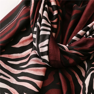 Macro detail of silk-like zebra print scarf with black and red textured knotting