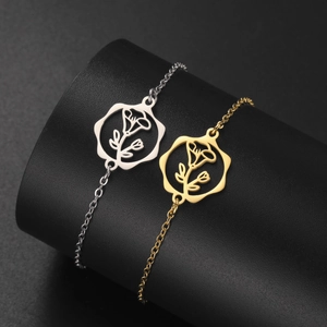 Detailed shot of gold and silver flower pendant bracelets on black display stands