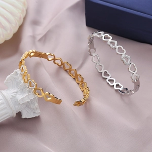 Bracelet jonc cœurs entrelacés en or et argent avec des cristaux de zircone brillants