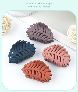 Leaf-shaped matte hair claws in navy, rust, pink, and grey colors for women