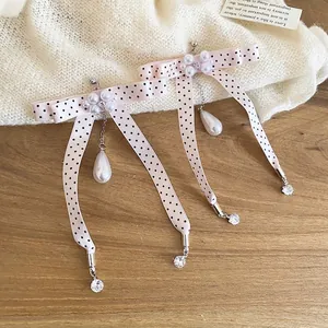 Elegant bow earrings with pink polka dots, dangling pearls, and long crystal chains