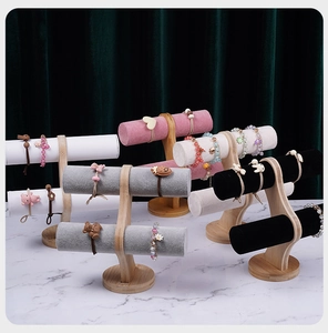 Close-up of T-bar jewelry display stands with wooden base and multi-color velvet rollers