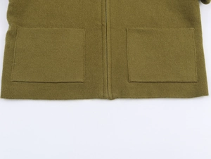 Dettaglio del cardigan in maglia verde oliva con cerniera metallica e ampie tasche applicate
