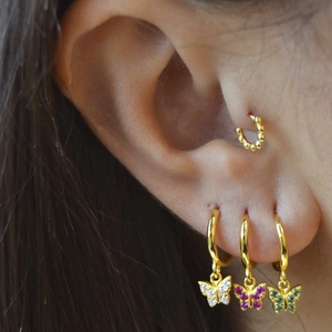 Detailed view of layered S925 silver butterfly earrings with pink and green crystals