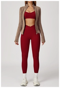 Detail of female sports set with deep red yoga wear and brown thick fleece jacket