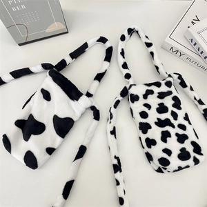Detail of plush cow print water bottle bags with soft faux fur texture and long straps