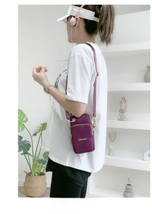Close-up of a purple nylon mini crossbody bag with multi-layer zippers and golden logo