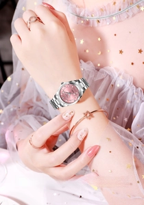 Detail of pink dial women's quartz watch with silver steel band and rhinestone markers