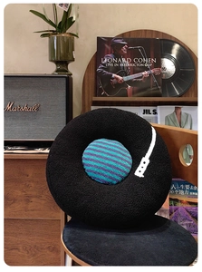 Creative vinyl record round pillow made of plush fleece on a wooden chair