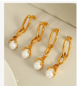 Macro detail of 18K gold-plated chain link earrings featuring elegant drop pearls