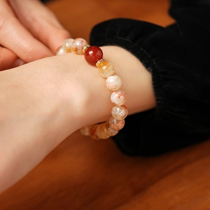 Détail du bracelet en perles d'agate jaune avec intercalaires sur un poignet