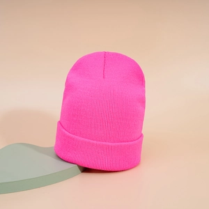 Détail du bonnet en maille côtelée rose vif avec tissage dense sur un présentoir