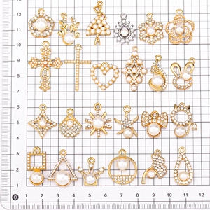 Golden alloy pendants with pearls and rhinestones shown on a scale for size measurement