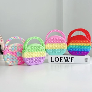 Detailed display of colorful heart-shaped silicone pop-it handbags for children in four colors