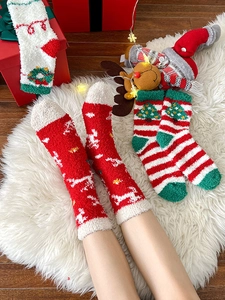 Close-up of festive Christmas coral fleece socks with reindeer and tree patterns