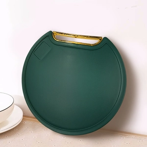 Emerald green round double-sided cutting board with a standing golden handle for kitchen