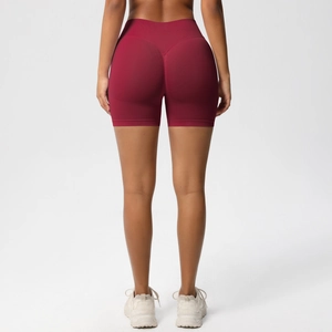 Macro view of seamless high-waist burgundy gym shorts with scrunch butt lifting effect