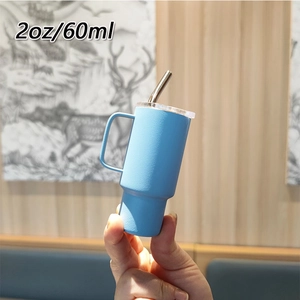 Detail showing hand holding 2oz blue stainless steel mini tumbler with straw