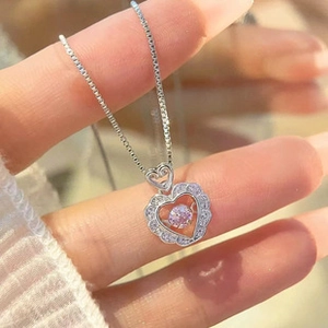 Detail of S925 silver heart necklace featuring a dancing pink stone and zircon border