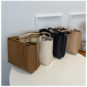 Detail view of large faux leather tote bags in brown, beige, black, and khaki colors