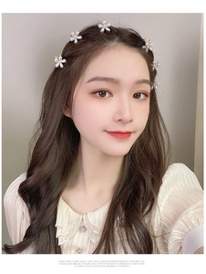 Detailed view of small pearl flower hair claws worn for a stylish half-up hairstyle