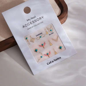 Macro shot of turquoise nail art charms with gold metal frames on packaging card