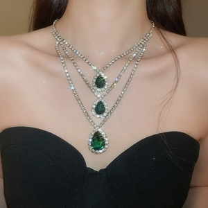 Dettaglio della collana a tre strati con pendenti a goccia verde smeraldo e strass