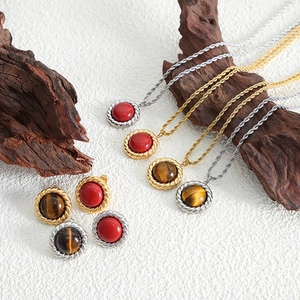 Vintage hip hop jewelry set with turquoise pendants and twisted metal chains on wood