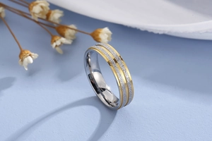 Detail of two-tone stainless steel ring with a gold frosted band and silver edges