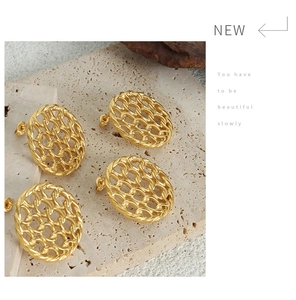 Detail of vintage gold hollow oval stud earrings with intricate woven texture on stone