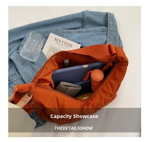Interior view showing large capacity of the orange quilted nylon crossbody bag