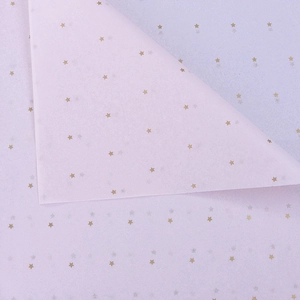 Close-up of lavender wrapping paper with gold star patterns and pleated texture