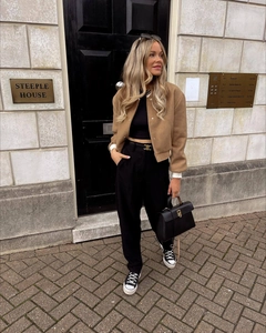 Urban street style featuring a cropped camel jacket and high-waisted wide-leg black trousers