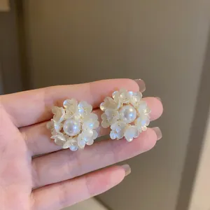 Détails macro de boucles d'oreilles fleur française avec perle et pétales en résine