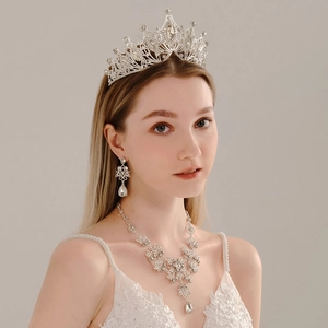 Elegant bridal jewelry set featuring a silver crown, necklace, and earrings with crystals