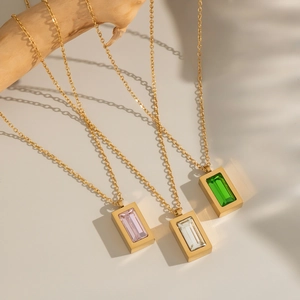 Golden necklaces with rectangular pink, clear, and green zircon pendants on a branch
