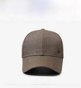 Détail de la casquette marron avec tissu texturé et emblème métallique extérieur rond