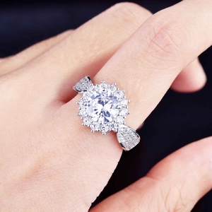 Detailed view of micro-pave zirconia ring with round center stone on a hand