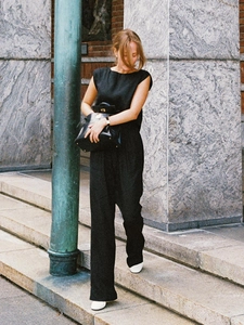 Detail eines schwarzen ärmellosen Leinen-Jumpsuits mit weitem Bein und fließender Textur