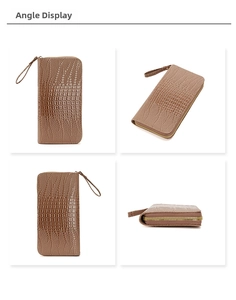 Detalle de cartera marrón con patrón de cocodrilo, cremallera dorada y correa de muñeca