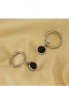 Détail de boucles d'oreilles plaquées 18K avec pierre noire, sans plomb ni nickel