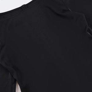 Détail du zip invisible et du tissu en satin noir lisse sur le dos de la robe chic