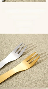Macro detail of food-grade stainless steel forks with smooth rounded tines in gold and silver