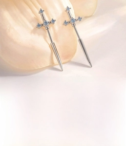 Macro shot of silver sword-shaped stud earring with blue zircon on 0.8x6mm bar