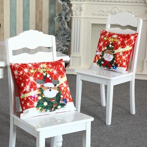 Housse de coussin de Noël lumineuse avec LED et broderie posée sur une chaise
