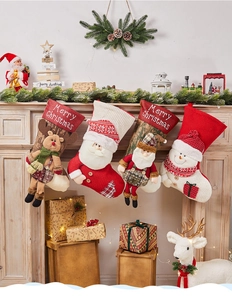 Detail of four knitted Christmas stockings with Santa, snowman, reindeer and elf characters